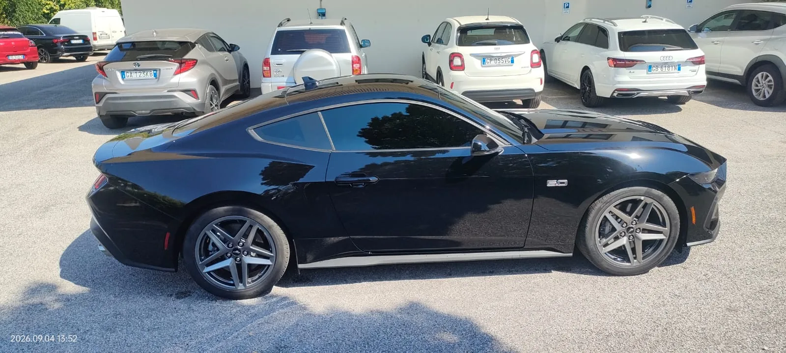 Ford Mustang nera con vetri oscurati, vista laterale